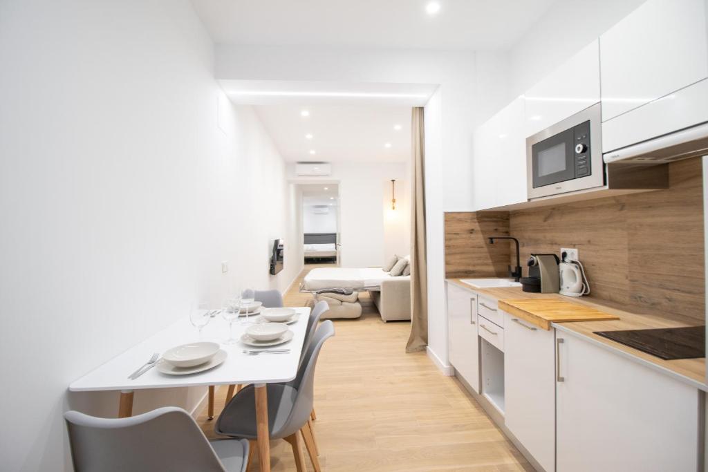 een keuken en eetkamer met een tafel en stoelen bij BedTime Suites by Concept Flats in Valencia