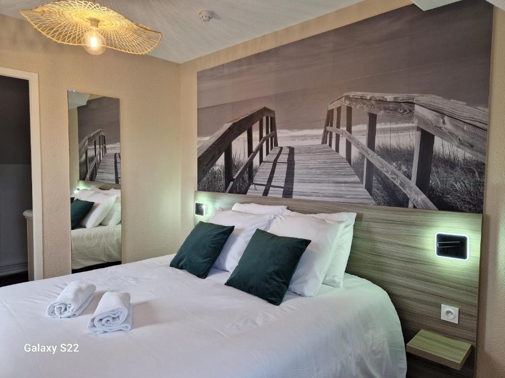 - une chambre avec un lit orné d'une peinture représentant une jetée dans l'établissement Hotel Eisenhower (ex King Hôtel), à Port-en-Bessin-Huppain