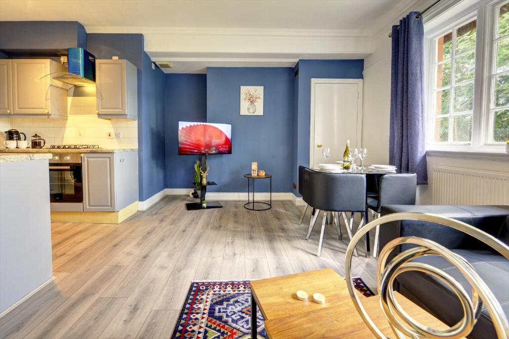 cocina y sala de estar con paredes azules y mesa. en Spacious, Luxurious Cliffes en Leicester
