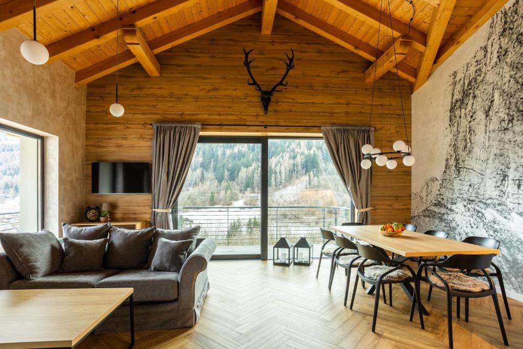 a living room with a couch and a table at CASA IL TRAMONTO Val di Sole in Commezzadura