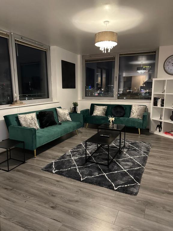 ein Wohnzimmer mit grünen Sofas und einem Teppich in der Unterkunft City Centre Luxury 2 Bed Apartment Free Parking in Liverpool