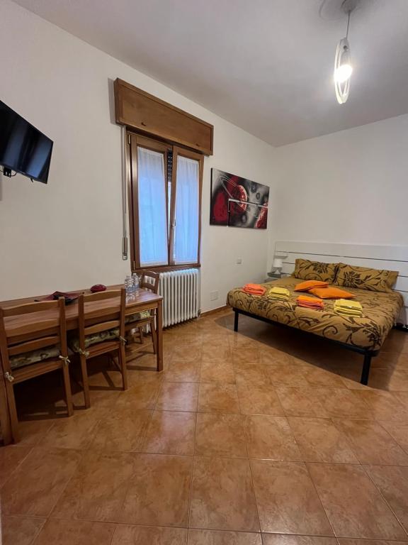 Zimmer mit einem Bett, einem Tisch und einer Bank in der Unterkunft Apartment De Rosa in Pero
