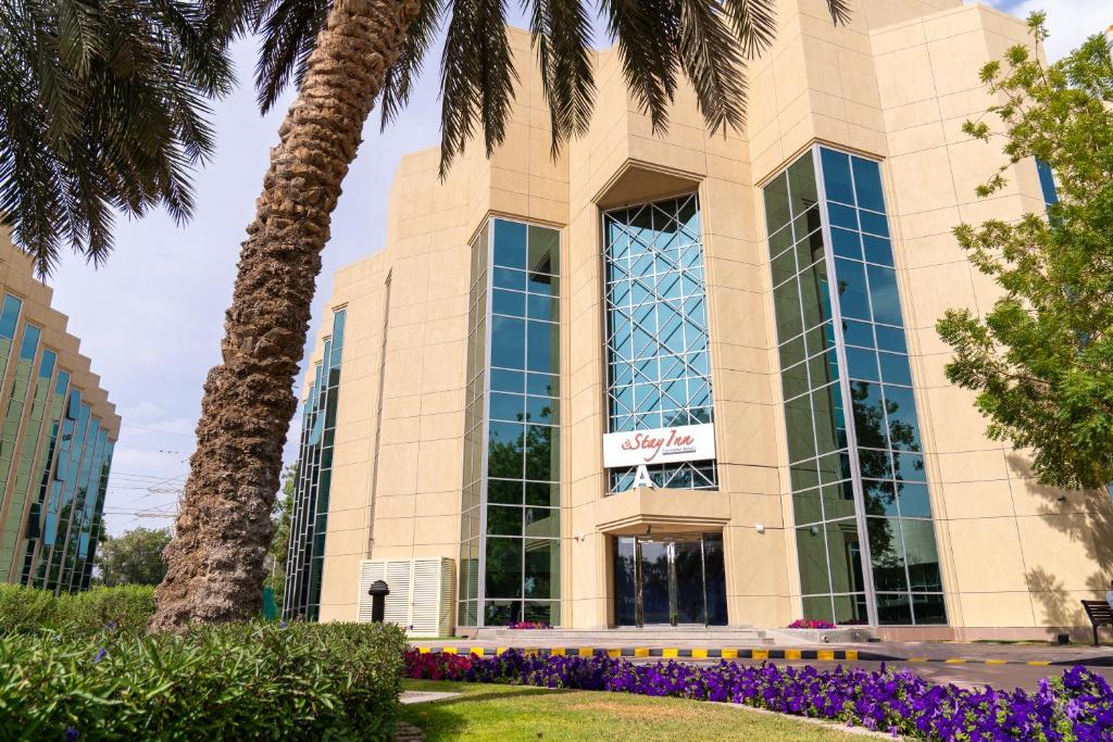 ein Gebäude mit einer Palme davor in der Unterkunft eStay Hotel in Dubai