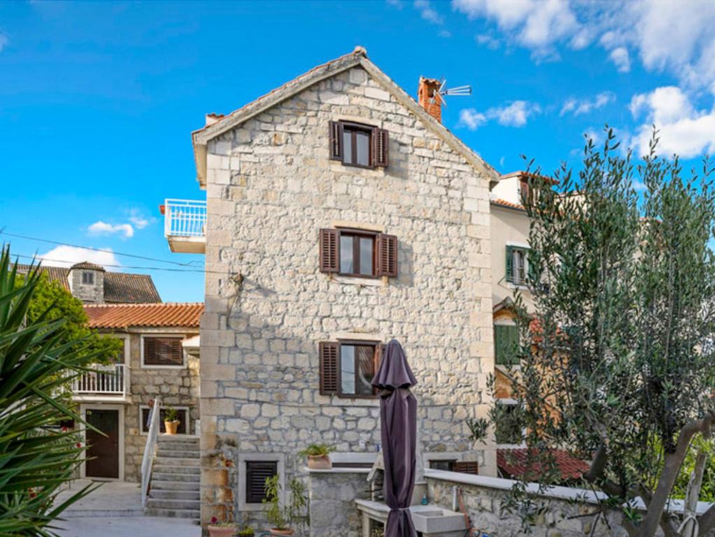 une maison en pierre avec un chat sur le toit dans l'établissement Apartments F&A, à Split