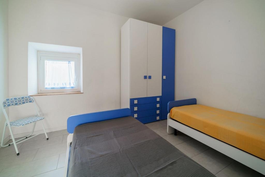 1 dormitorio con 1 cama y 1 silla en La Conchiglia Patresi - Goelba, en La Guardia
