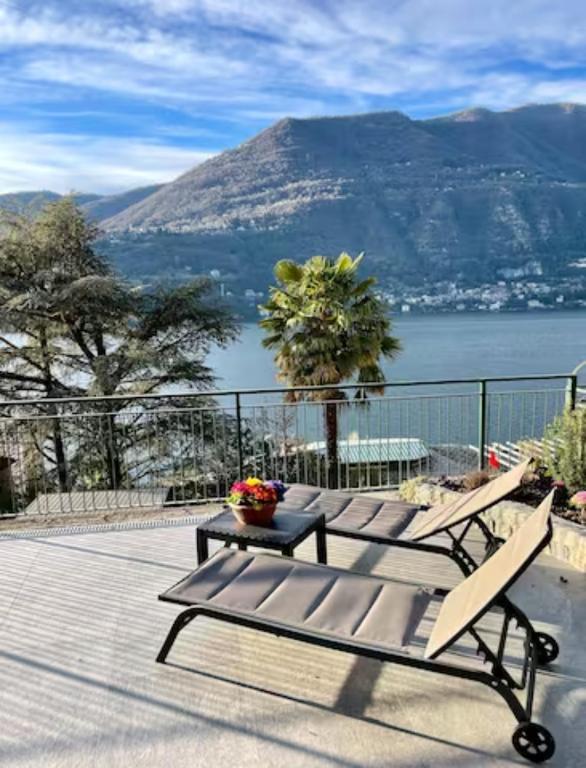 un patio con 2 panche e vista sull'acqua di La Casa della Bruna, wonderful lake view & parking a Blevio