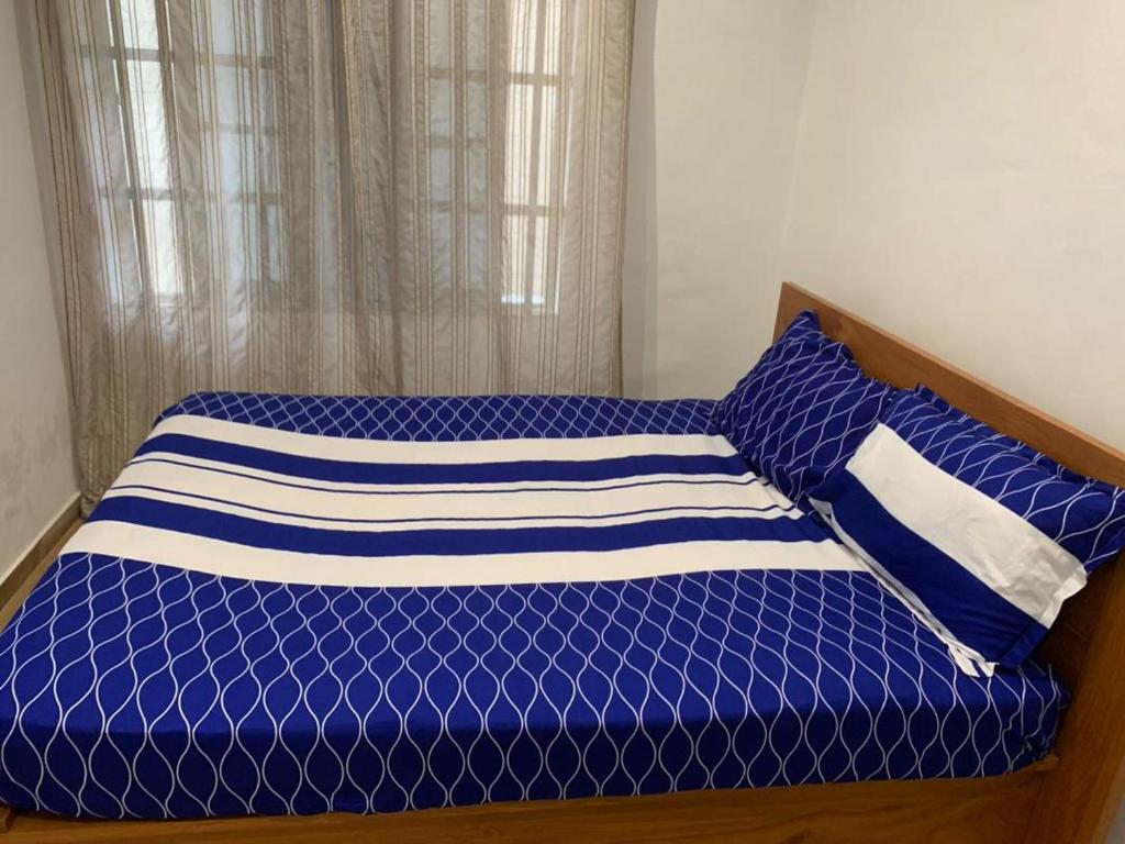 un letto blu con cuscini blu e bianchi sopra di RESIDENCE KWABO a Cotonou