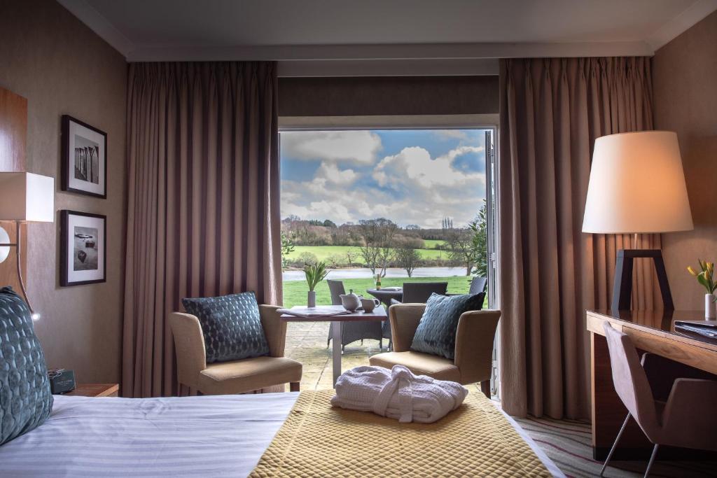 a hotel room with a bed and a large window at Lakeside Park Hotel &amp; Spa in Ryde