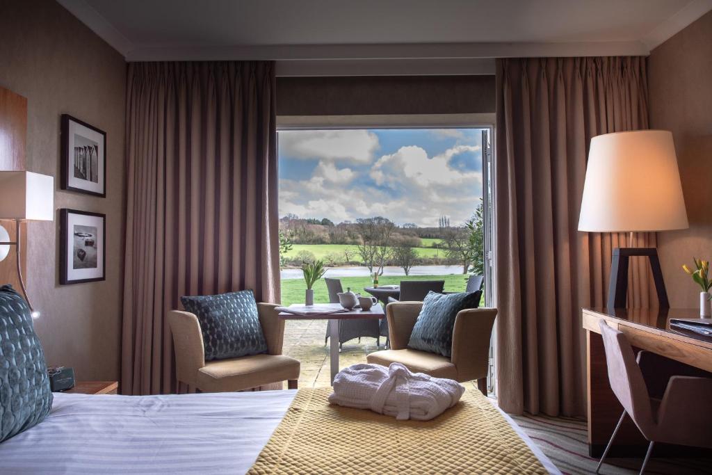 a hotel room with a bed and a large window at Lakeside Park Hotel & Spa in Ryde