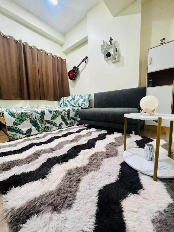 ein Wohnzimmer mit einem Sofa und einem Teppich in der Unterkunft Northwoods Place in Mandaue City