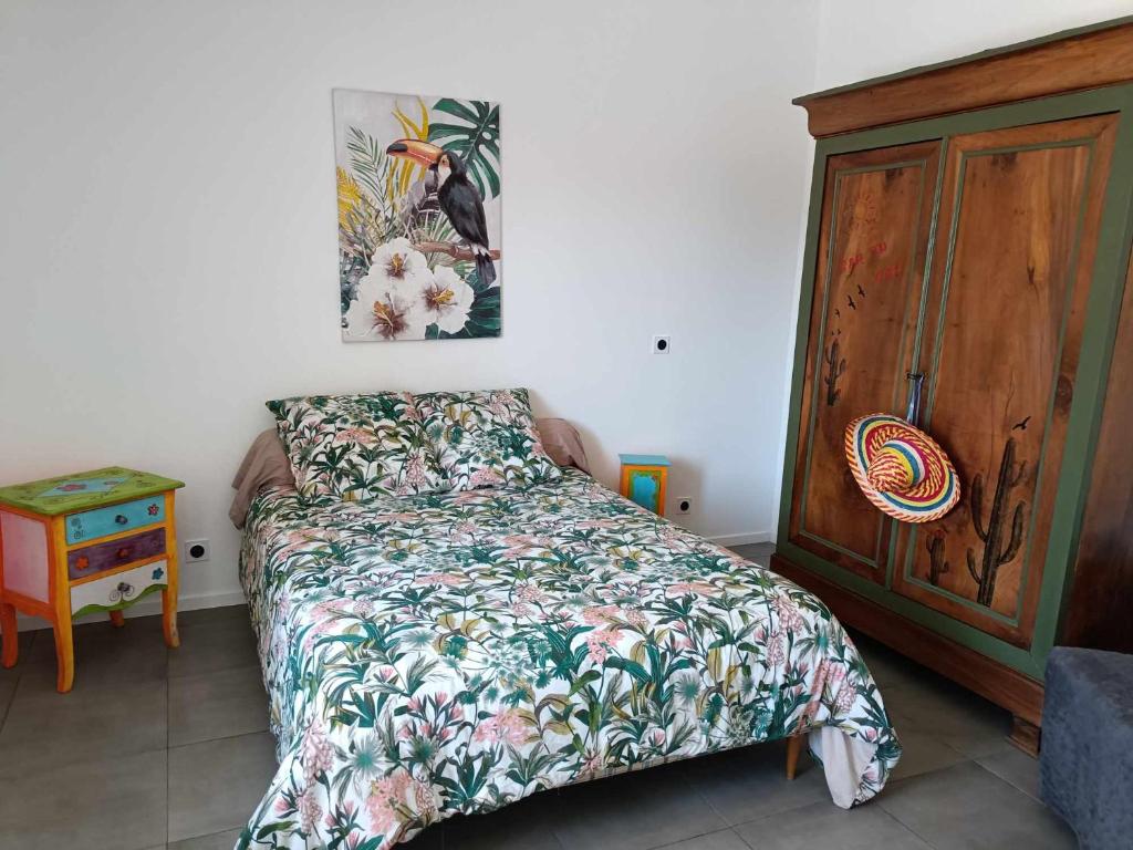 een slaapkamer met een bed en een houten kast bij Cabaña MEXICANA in Fougeré