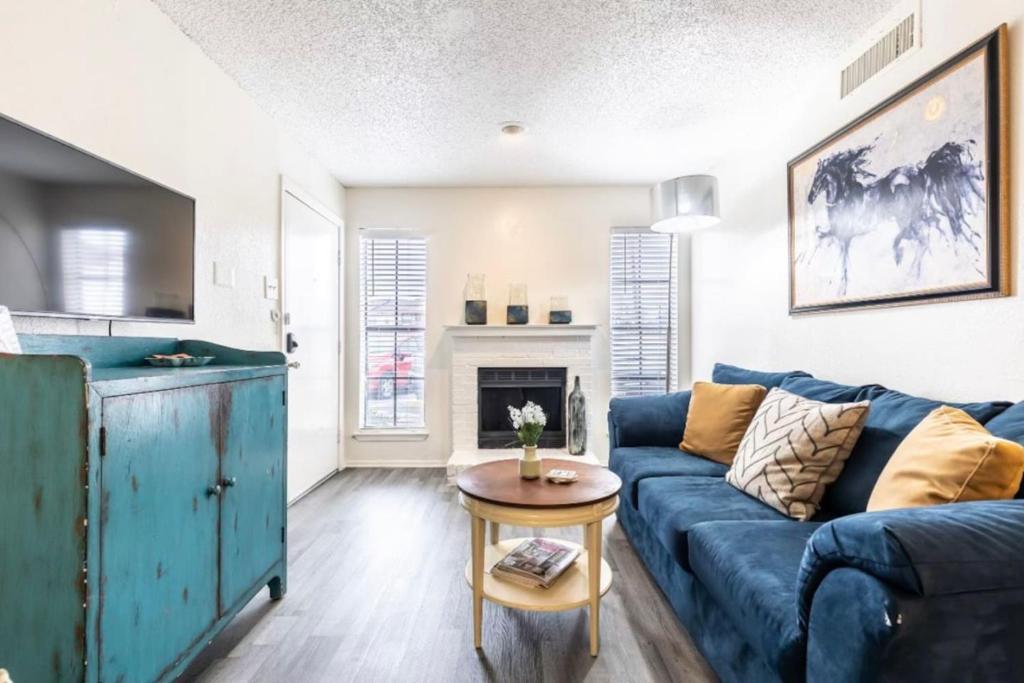 Una sala de estar con un sofá azul y una mesa. en Stay Awhile In This Cozy 1 Bed Apt, en Dallas