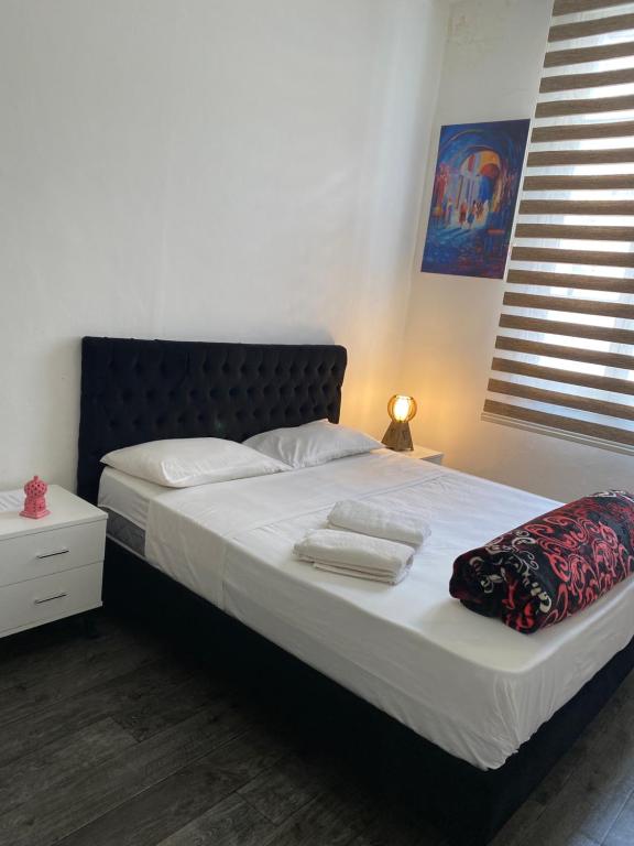 Schlafzimmer mit einem Bett mit weißer Bettwäsche und einem Fenster in der Unterkunft Tunis Lafayette in Tunis