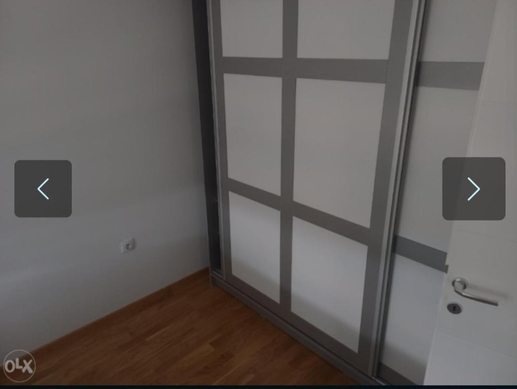 une porte en verre dans une pièce munie de deux flèches. dans l'établissement Apartman KoprenaZ, à Banja Luka