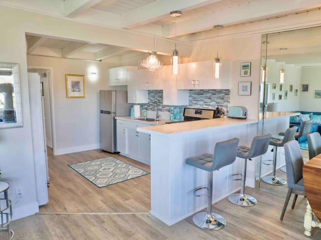 a kitchen with a counter and stools in it at STUNNINGLY PERFECT Beach ALL NEW REMODEL Galore in Laguna Beach