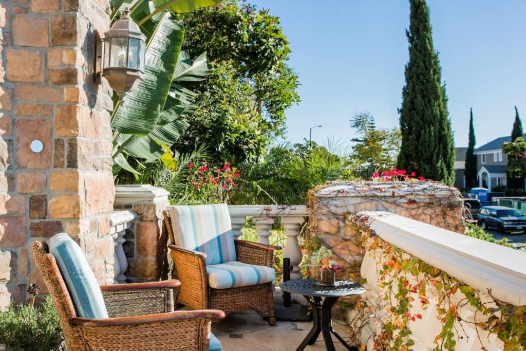 une terrasse avec des chaises et une table sur un mur dans l'établissement Unparalleled Villa Apartment in an Enchanting Village, à Laguna Beach