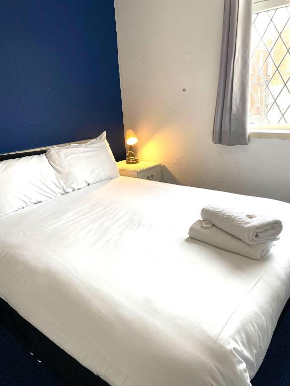 a white bed with two towels on top of it at The Regency Hotel in Blackpool