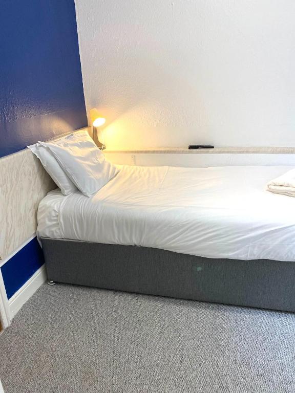 a bed in a small room with a white bedsheet at The Regency Hotel in Blackpool