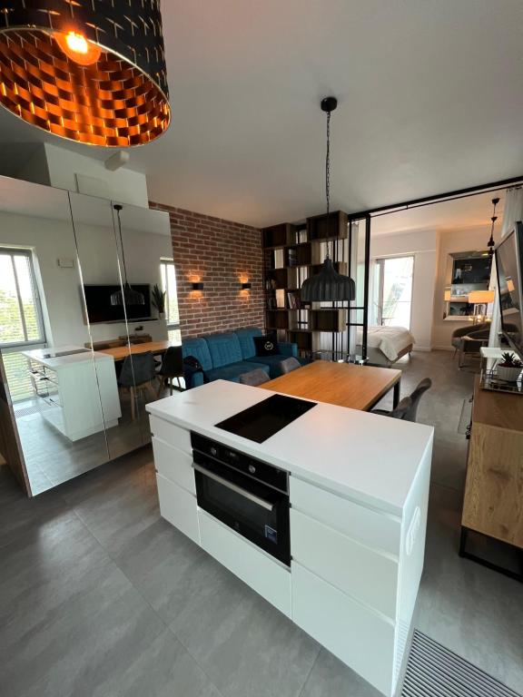 a kitchen and living room with a white counter top at Apartament Faltom Marina Gdynia in Gdynia