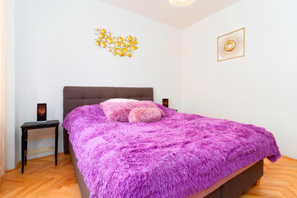 a bedroom with a purple blanket on a bed at Brilliant Deluxe Suite in Prague