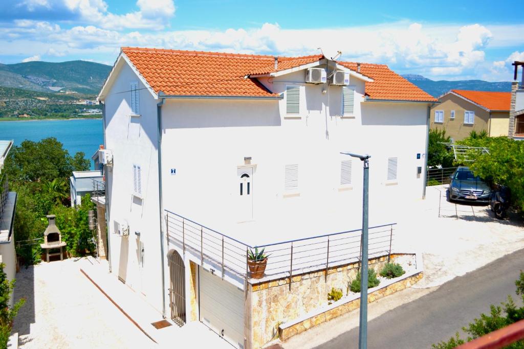 una casa blanca con techo naranja en Apartments Bellevue, en Trogir