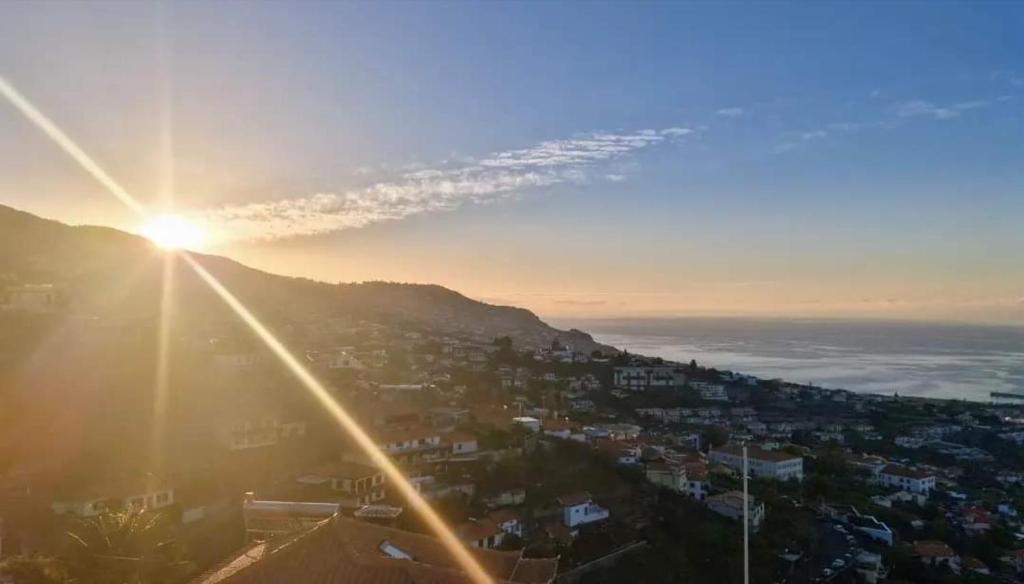 Blick auf den Sonnenuntergang über einer Stadt in der Unterkunft Dream View in Funchal