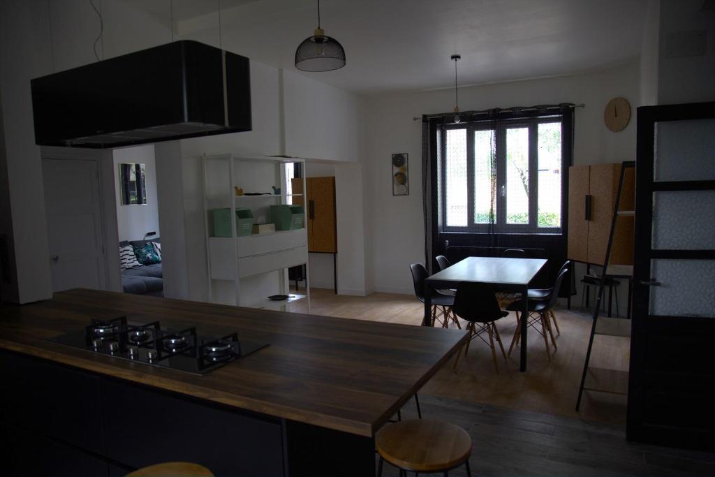 cocina y sala de estar con mesa y comedor en Maison de 100 M2 équipée de 4 chambres. en Valence
