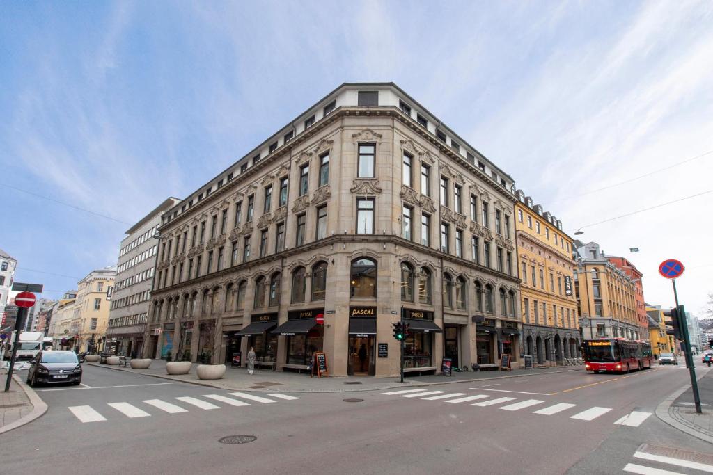 un gran edificio en una calle de la ciudad con un autobús en Maya Apartments - Sentrum en Oslo