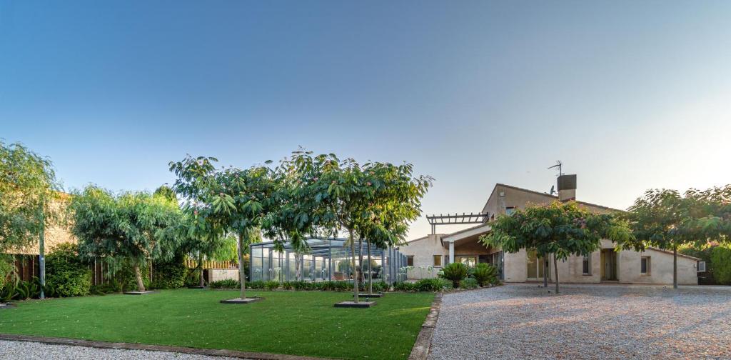 a house with a yard with trees and a building at Can Vilaveda in Vilanant