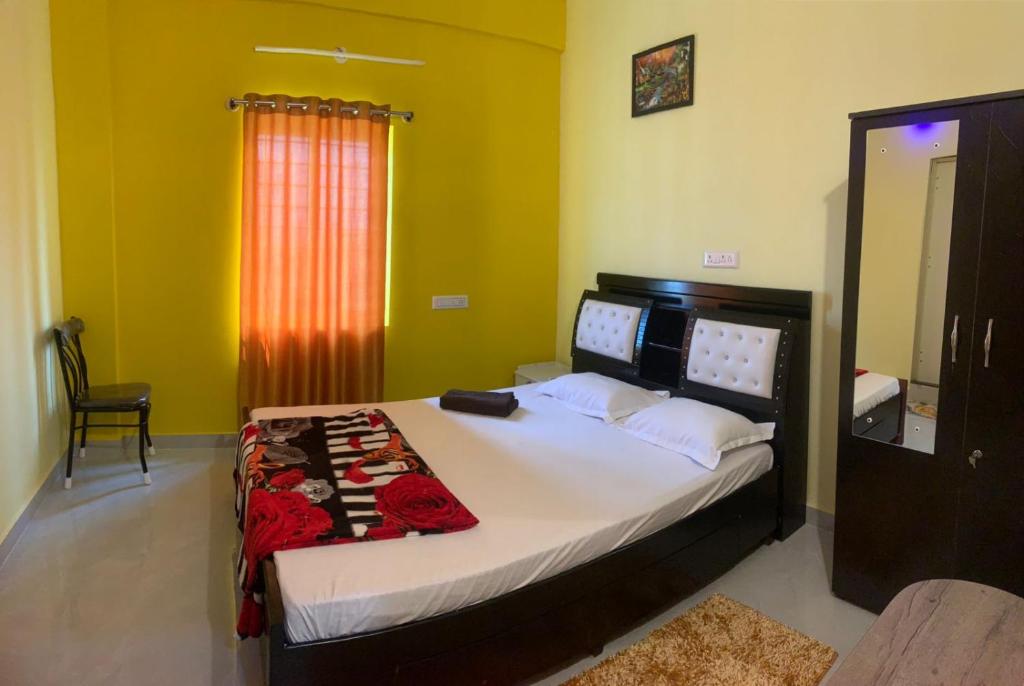 バンガロールにあるCozy Prime-3BHK Near BIEC Exhibition Bangalore & IKEAのベッドルーム1室(赤いカーテン付きの大型ベッド1台付)