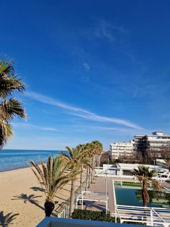 a beach with palm trees and the ocean at Martur Resort in Termoli