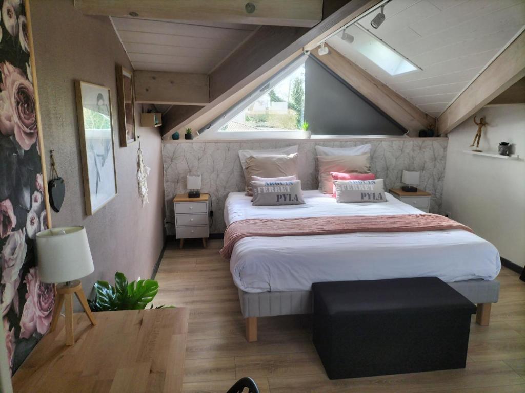 a bedroom with a large bed in a attic at Au bord du vieux Moulin in Mérignac