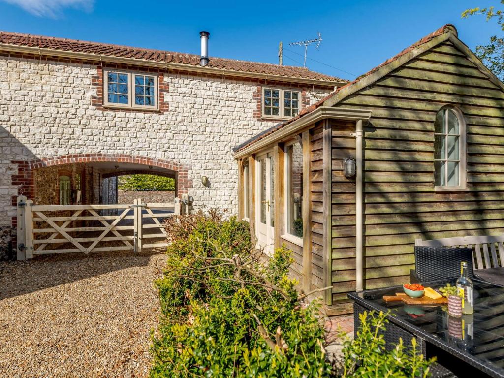 a barn with a wooden gate and a building at 3 Bed in Thornham KT104 in Thornham