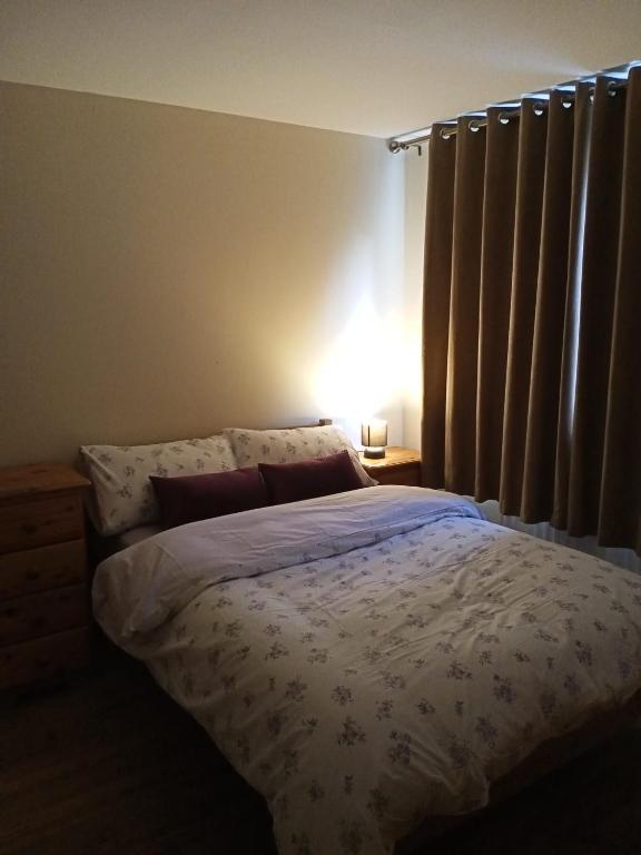 a bedroom with a bed with a white comforter at Highly Comfortable Home in Hatfield