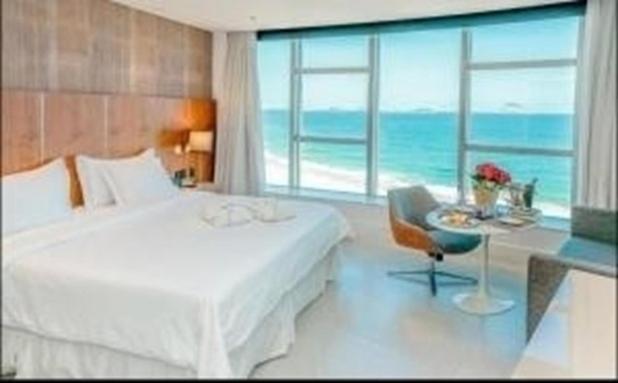 Schlafzimmer mit einem Bett und einem Fenster mit Meerblick in der Unterkunft Hotel Nacional Rio de Janeiro in Rio de Janeiro
