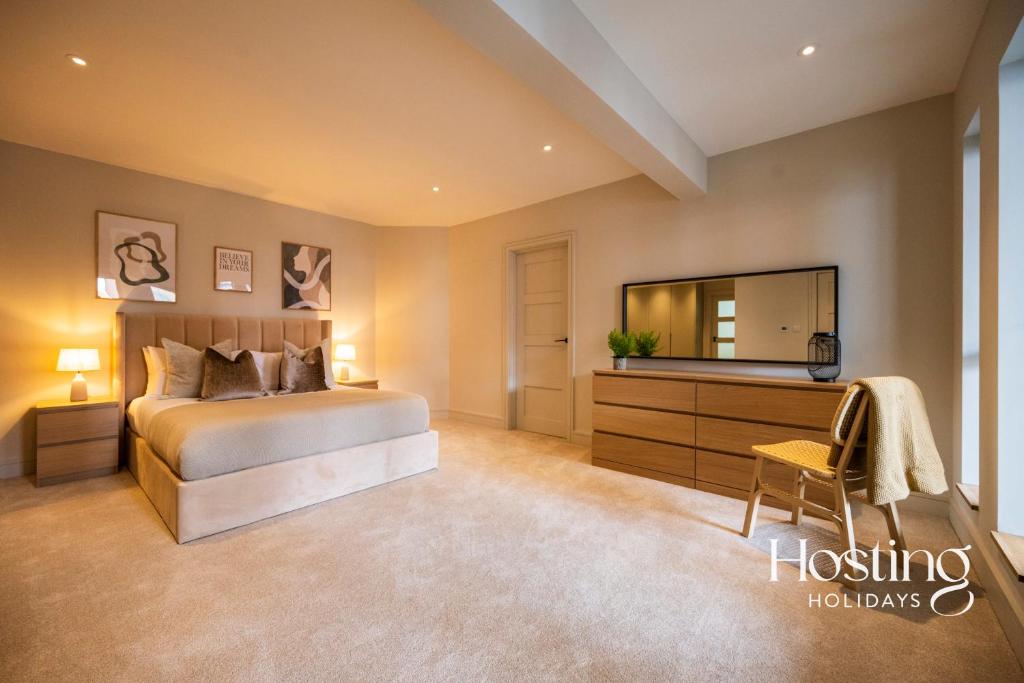 ein Schlafzimmer mit einem Bett, einer Kommode und einem Spiegel in der Unterkunft The Elizabeth Suite - 3 Bedroom With Parking in Henley on Thames