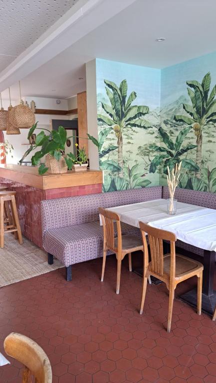 a restaurant with a table and chairs and a mural at Boutique hôtel Maria-Christina in Saint-Jean-de-Luz