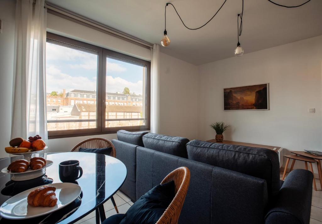 un soggiorno con divano blu e tavolo di rouen gare logement avec parking a Rouen