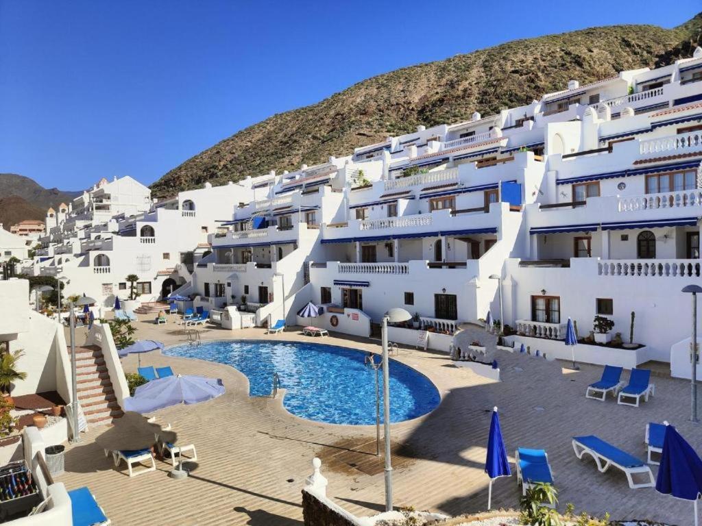 a group of white buildings with a swimming pool at Port Royale Los Cristianos in Los Cristianos