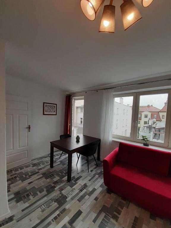 a living room with a red couch and a table at Sopot Center Saba Appartement in Sopot