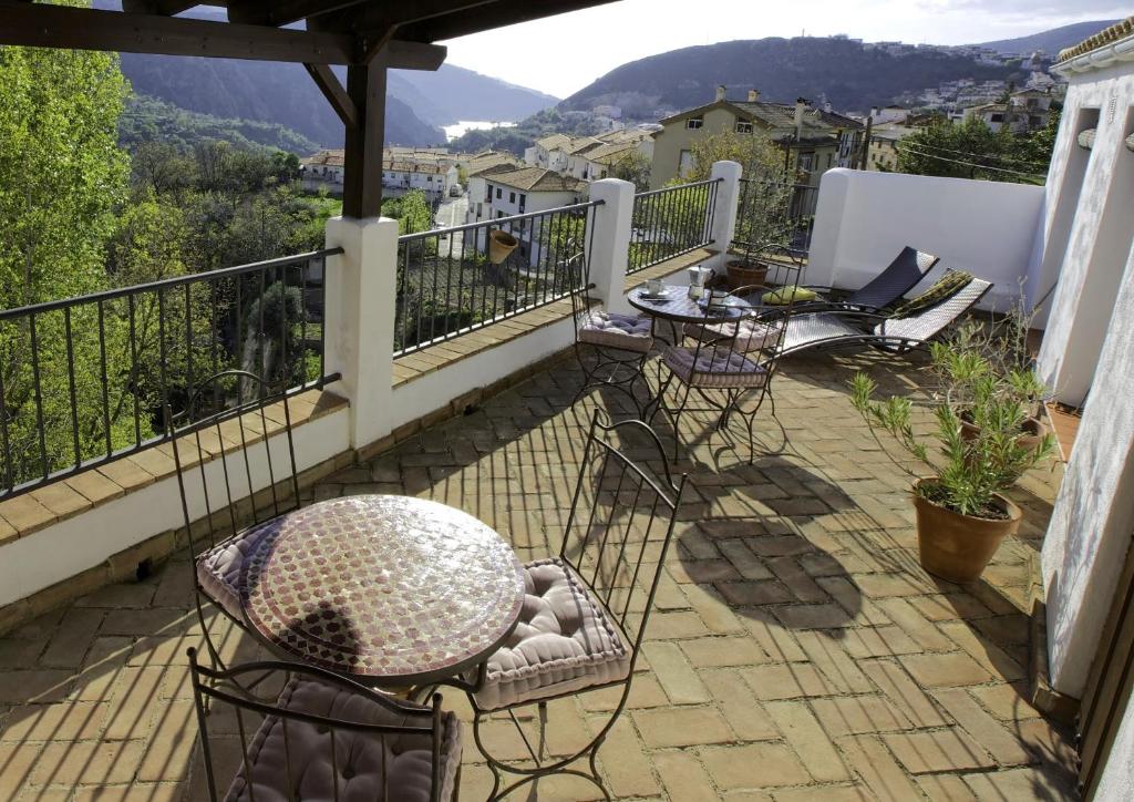 a balcony with chairs and a table and a view at Casa Rural Arroyo de la Greda in Güéjar-Sierra