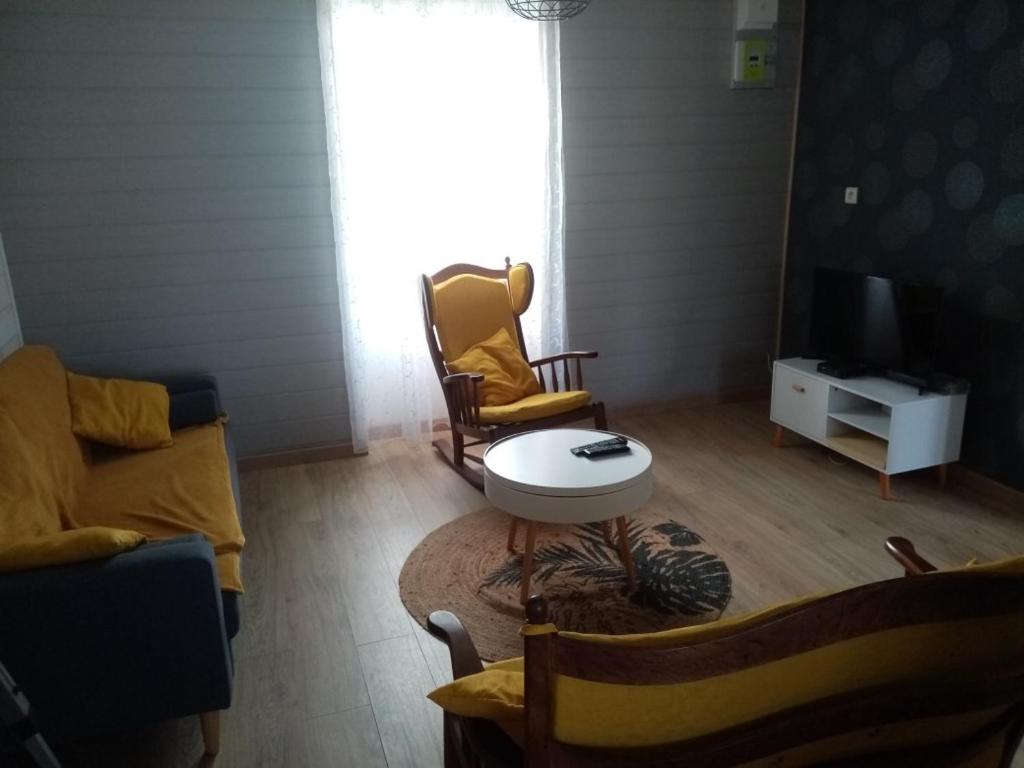 a living room with two chairs and a television at Maison Bretonne in Cléden-Cap-Sizun