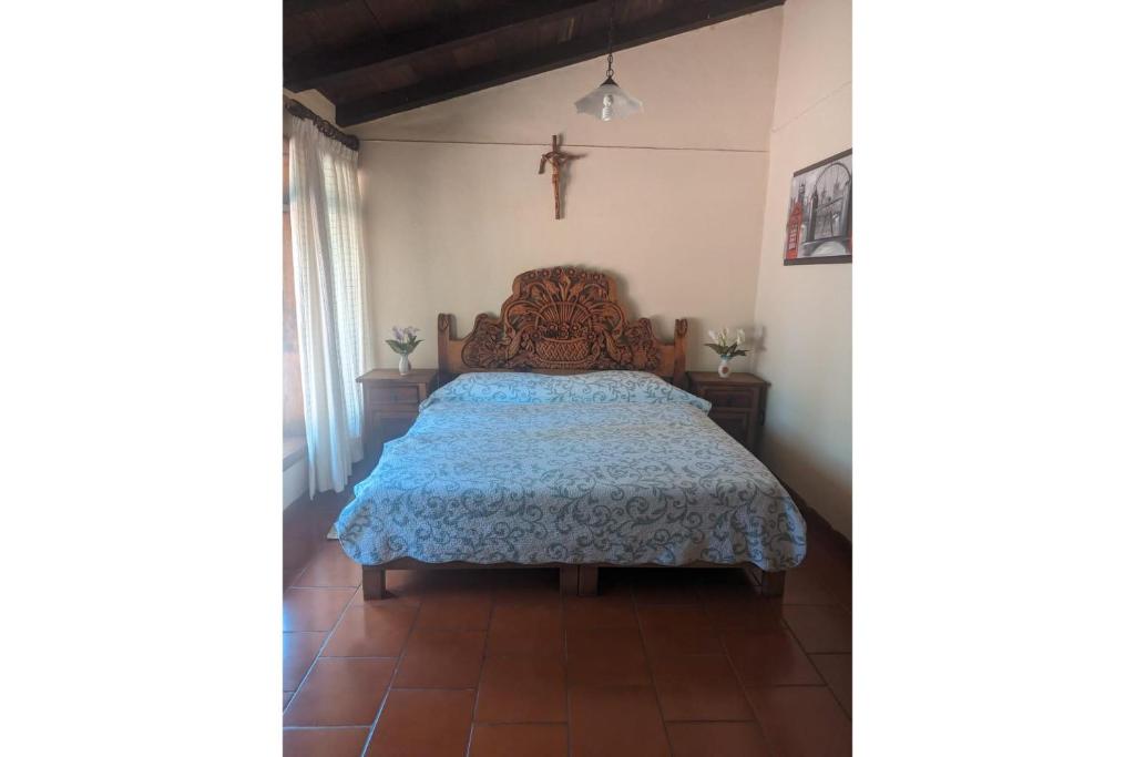 a bedroom with a bed with a blue bedspread at OYO Los Alcatraces in Tzintzuntzán