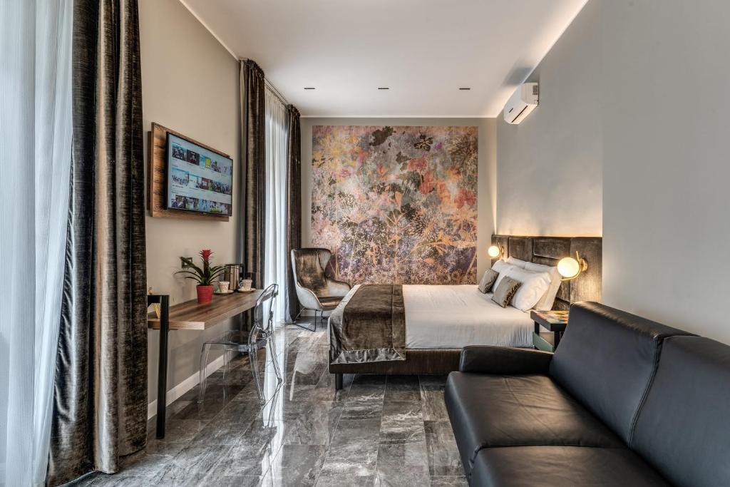 Habitación de hotel con cama y sofá en Apollo Boutique Hotel en Roma
