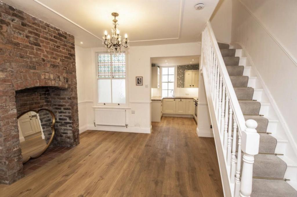 a living room with a brick fireplace and stairs at City Chester Entire House Central in Chester