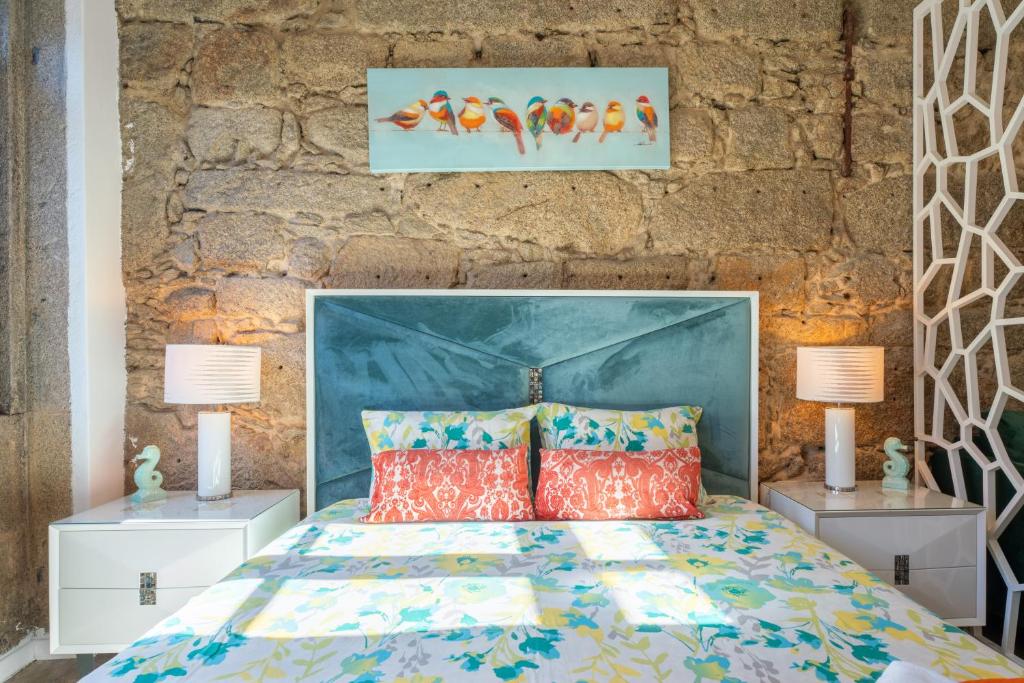 a bedroom with a bed with a blue headboard and two lamps at Apartamento Qian porto Centro 2 in Porto