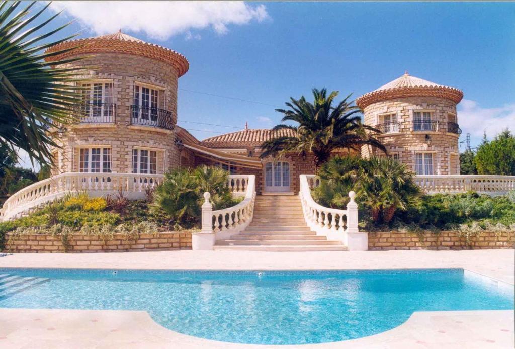 een groot huis met een zwembad ervoor bij Villa vue mer-piscine-jacuzzi-billard-homecinema in Mireval