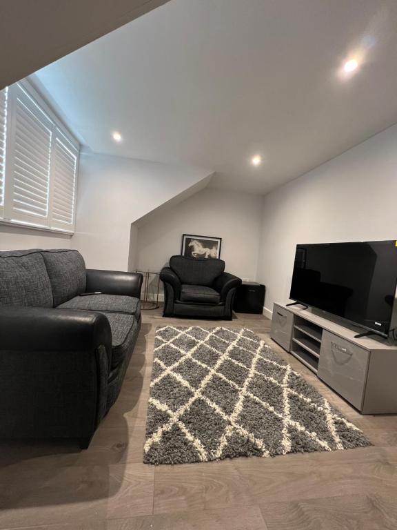 a living room with a couch and a flat screen tv at Beautiful Shared One Bed Flat (Room/Front) in Strood