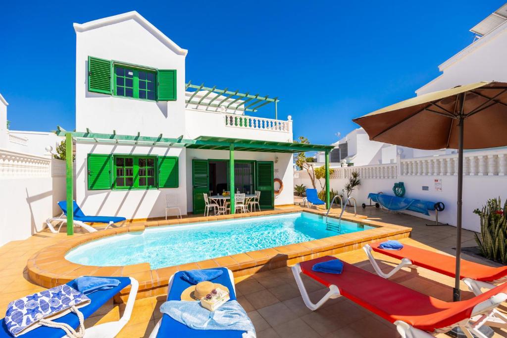 uma villa com piscina em frente a uma casa em Villa Alegranza em Puerto del Carmen