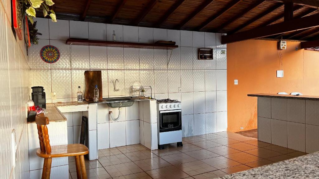 a kitchen with a stove and a sink at Pousada das Cores in Olímpia